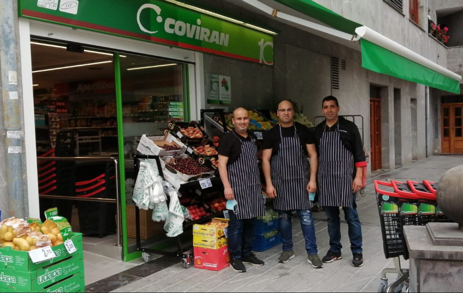 Los tres empleados frente al nuevo supermercado Covirán.