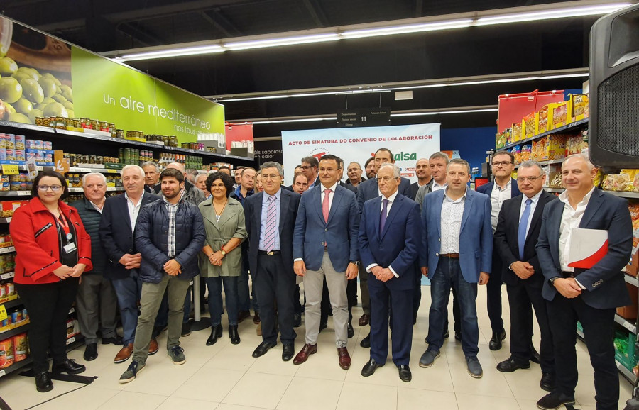 Los representantes de las entidades durante la firma en un supermercado Vegalsa-Eroski.