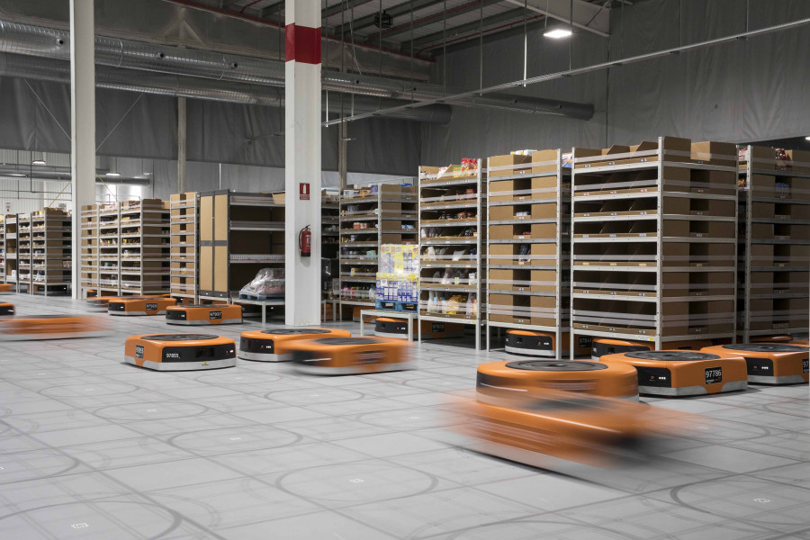 Los robots levantan y desplazan las estanterías por el almacén.